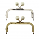 Twin hinged metal interchangeable bag frame, bag fastening with pearl knobs